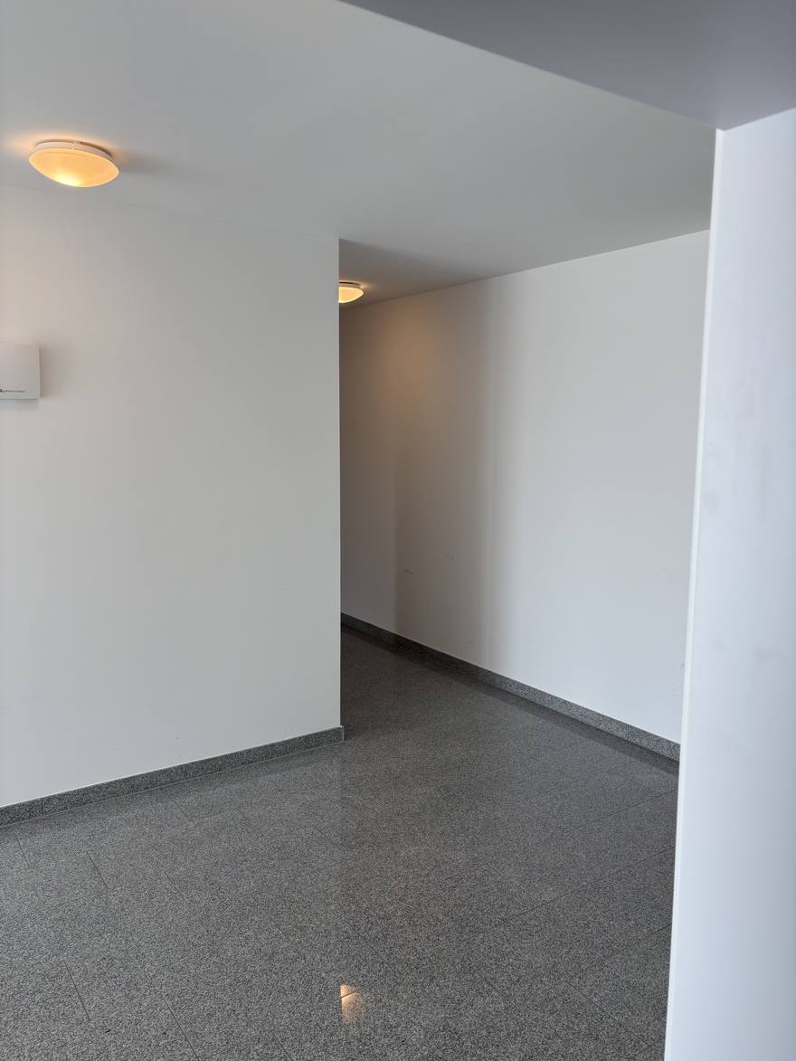 A hallway on one of the floors, with granite tiles and white walls